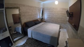 Un dormitorio con cama, espejo, armario y alfombra estampada de leopardo.
