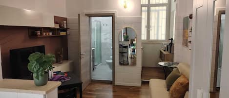 Una sala de estar con televisor, sofá y comedor con mesa y sillas.