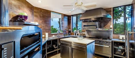 Cocina industrial con un horno grande, una estufa y una campana de ventilación.