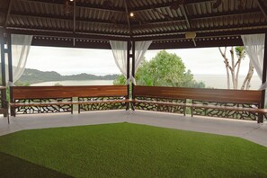 Un espacio de descanso cubierto con un banco y vistas a un paisaje natural.