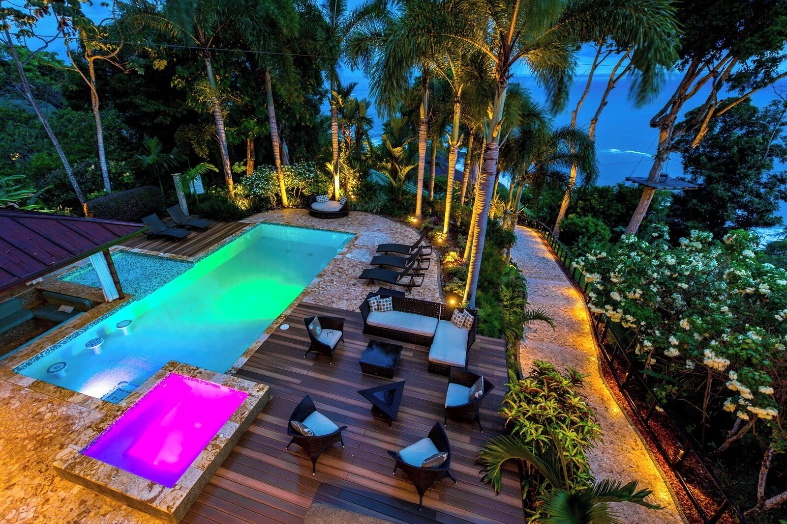 Un área de piscina con un jacuzzi, sillas de descanso y una terraza.