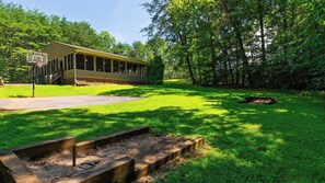A building with a basketball hoop, surrounded by a well-maintained lawn and trees. - Lazy Bear by Avantstay Mountain-view Condo Shared Pool + Hot Tub + Sauna Near Gatlinburg (Gatlinburg)