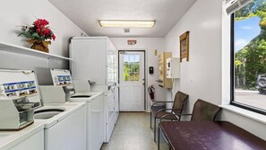 A laundry room with a washing machine, dryer, and a small table with chairs. - Lazy Bear by Avantstay Mountain-view Condo Shared Pool + Hot Tub + Sauna Near Gatlinburg (Gatlinburg)