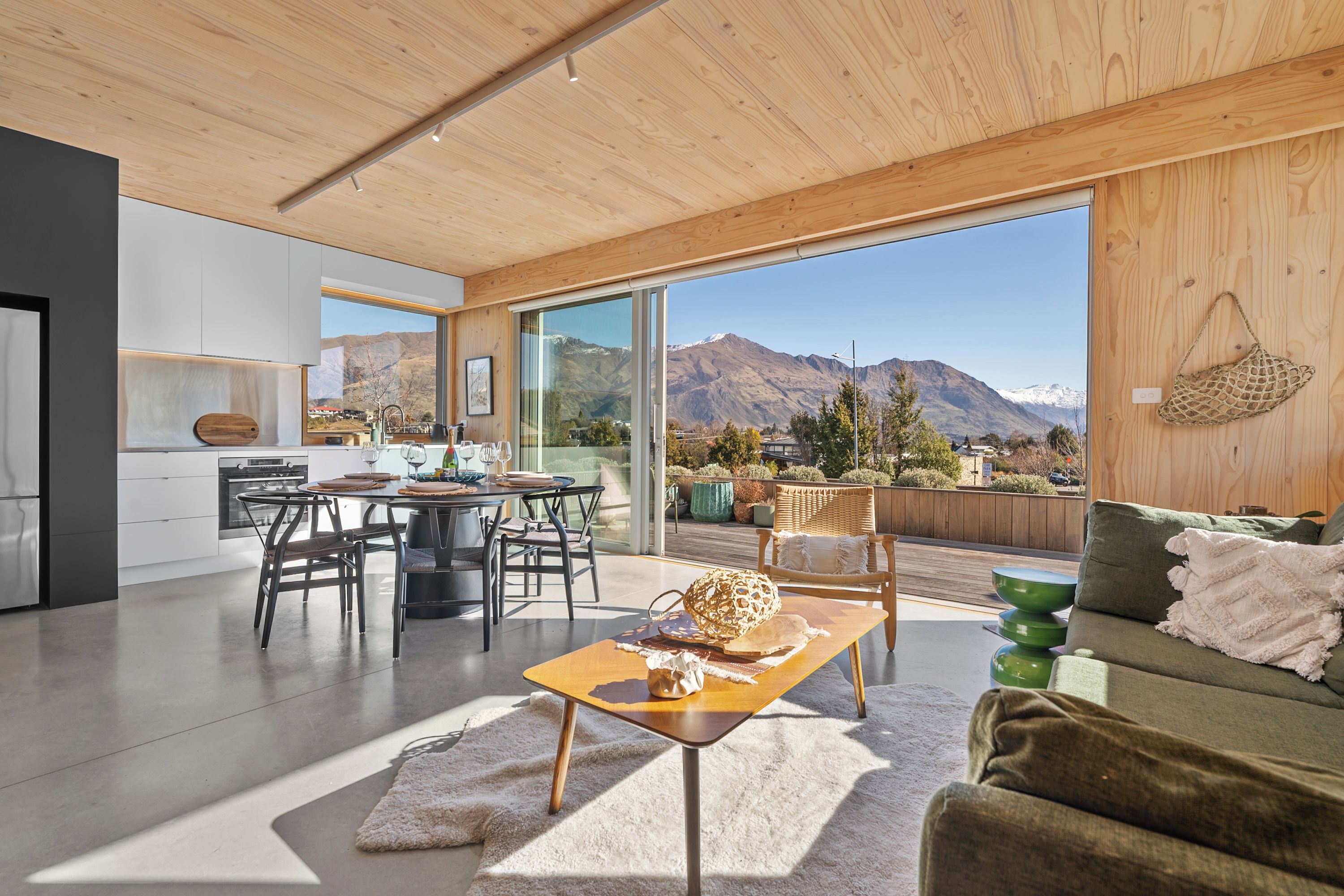 Un interno moderno con zona pranzo, cucina e vista sulle montagne.