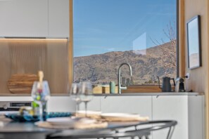 A modern kitchen with a large window overlooking a mountainous landscape. - Architecturally Designed - Wanaka Holiday Home (Wanaka)