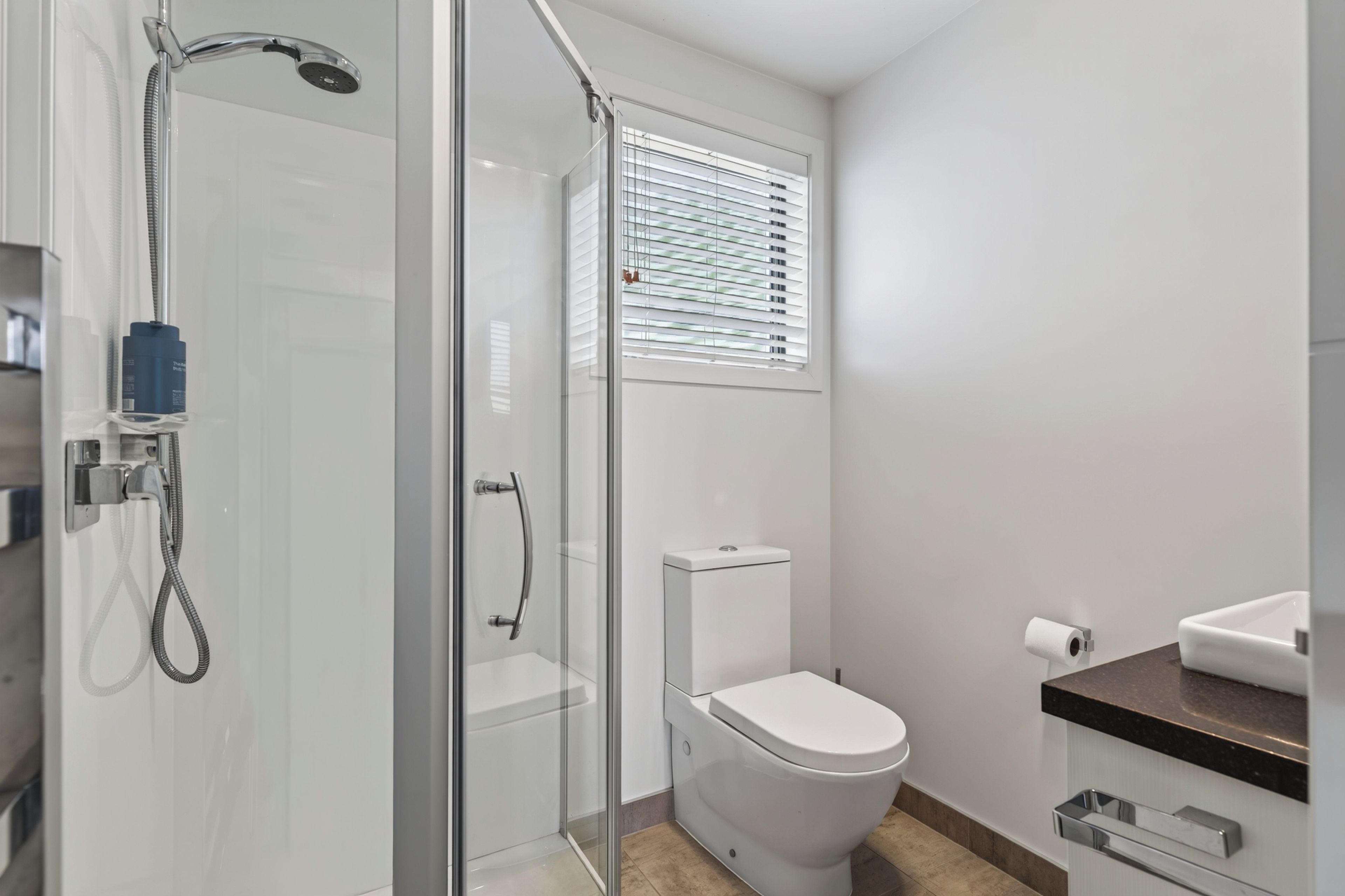 Une salle de bain moderne avec une douche à parois de verre, des toilettes et un lavabo.