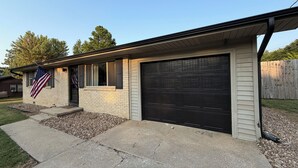 Um prédio residencial com garagem, entrada para carros e uma antena.