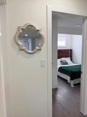 Ein Schlafzimmer mit einem Bett, einer grünen Decke und einem Holzkopfstück.
