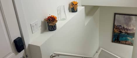 A staircase with a handrail, a door with a keycard reader, and a wall-mounted picture.