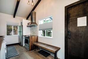 A modern kitchen with a built-in oven, a wooden bench, and a large window. - Stylish 2 Bedroom in Trees. On Free Bus Route (Breckenridge)