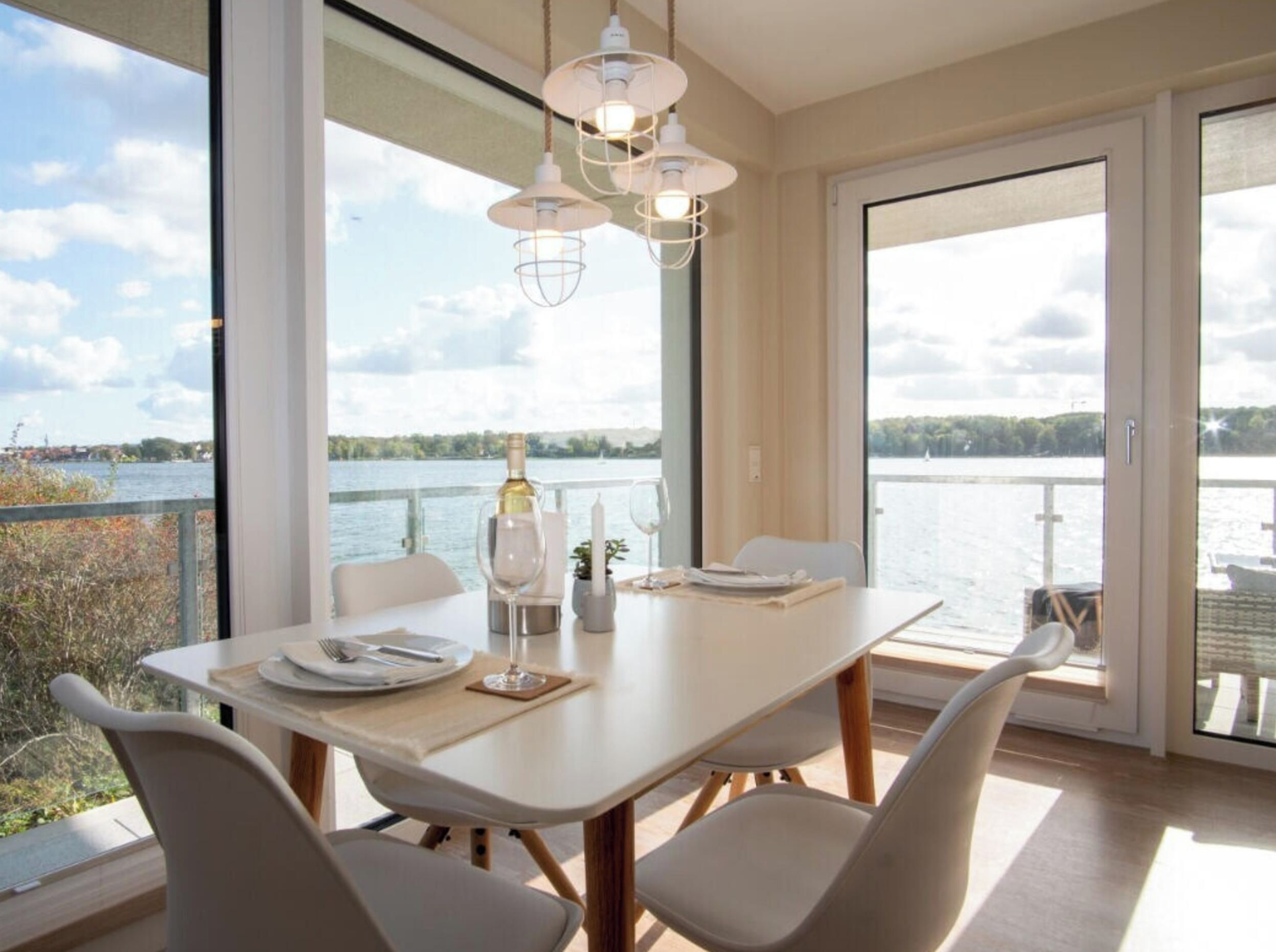 En matplats med ett bord dukat för två personer, med utsikt över en vattenyta.