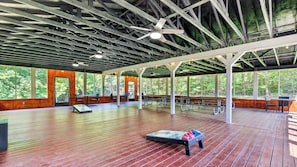An indoor pavilion with a wooden floor, ceiling fans, and large windows offering a view of the outdoors. - Bear Ridge by Avantstay Smoky Views + Indoor Pool + Sauna & Spa Near Park Trails (Gatlinburg)