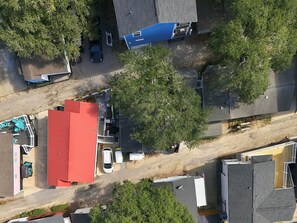 An aerial view of a residential area with multiple houses, a red-roofed building, and a blue-roofed structure. - Saltwater Shanty GolfCart•Linens•OceanLakes (Horry County)