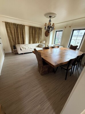 A dining area with a wooden table and chairs, a sofa, and a chandelier. - Spacious 4-bedroom house in tranquil San Rafael with AC (San Rafael)