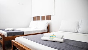 A hotel room with two single beds, a wooden headboard, and a grey bedspread. - HOTEL PALM BAY  (Bello horizonte SANTA MARTA)