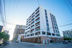 A multi-story building with a modern architectural design, featuring balconies and large windows.