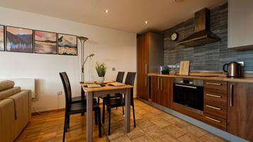A modern kitchen with wooden cabinets, a Bosch oven, and a tiled backsplash.