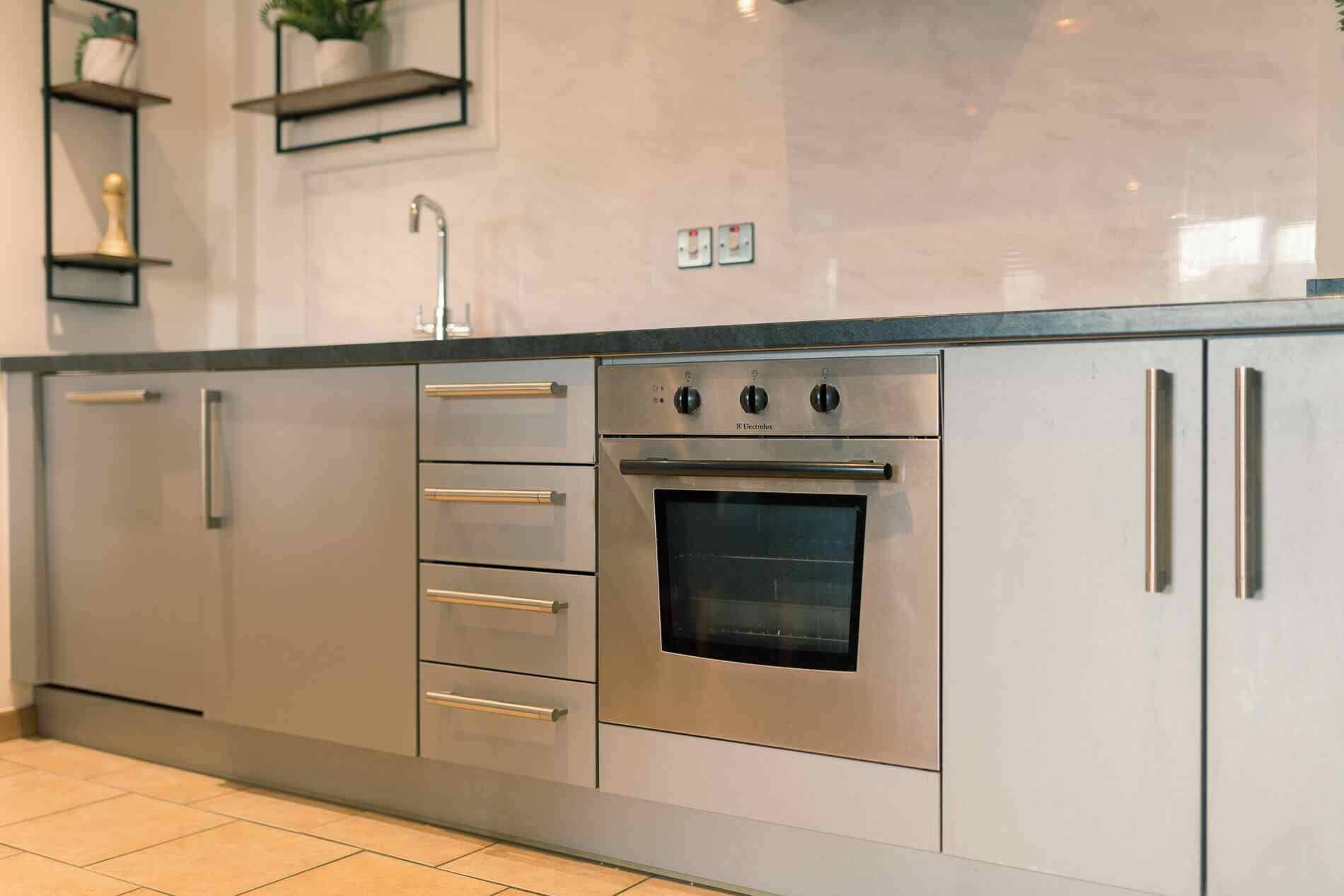 A kitchen with stainless steel appliances, including a built-in oven and a sink.