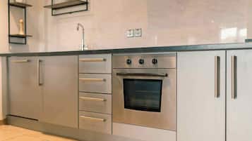 A kitchen with stainless steel appliances, including a built-in oven and a sink.