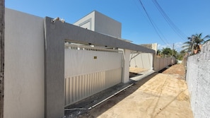 A gated residential area with a concrete wall, a metal gate, and a paved path.