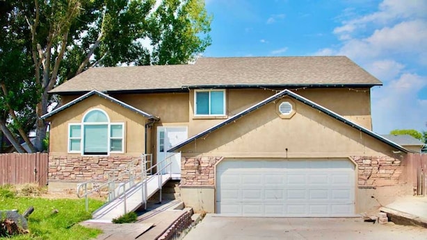 A single-story house with a garage, a front porch, and a stone foundation. - Spacious, accessible family home with stair lift, full kitchen & quiet location (Provo)