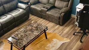 A living room with a sectional sofa, a coffee table, and a computer desk with a chair. - Spacious, accessible family home with stair lift, full kitchen & quiet location (Provo)