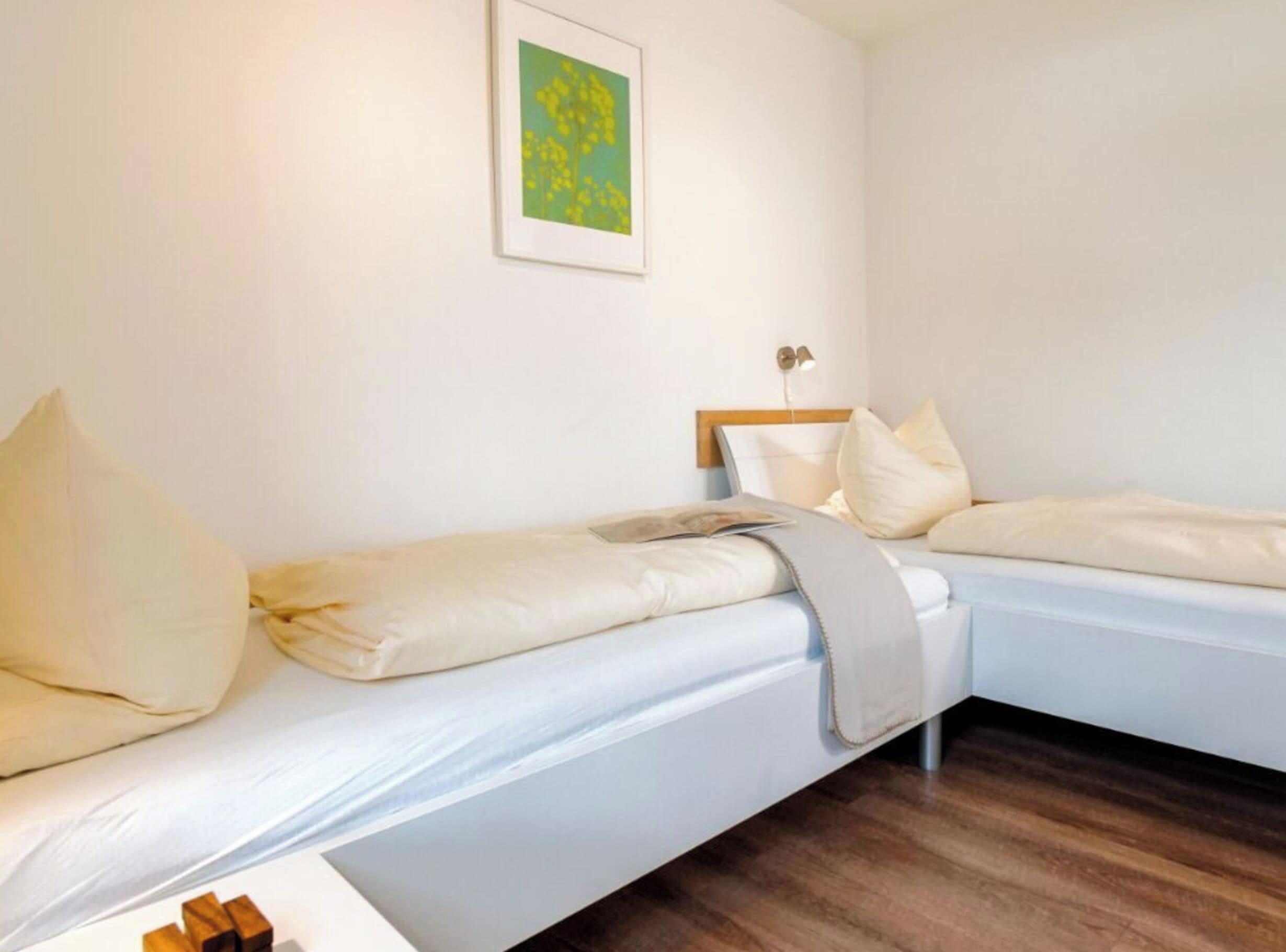 Un letto singolo con testiera, un comodino e una lampada.