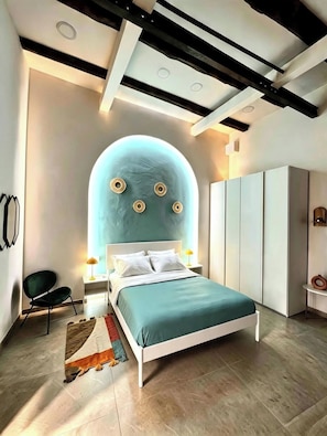 Quarto moderno com cama, cadeira, guarda-roupa e um detalhe único na parede.
