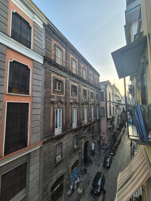 Uma rua estreita ladeada por edifícios, com várias janelas e varandas.