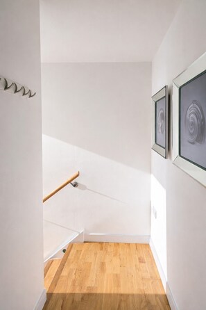 A staircase with a wooden handrail leading to a landing. - Sidemersey Livings-Unmatched Views, Secure Parking (Liverpool)