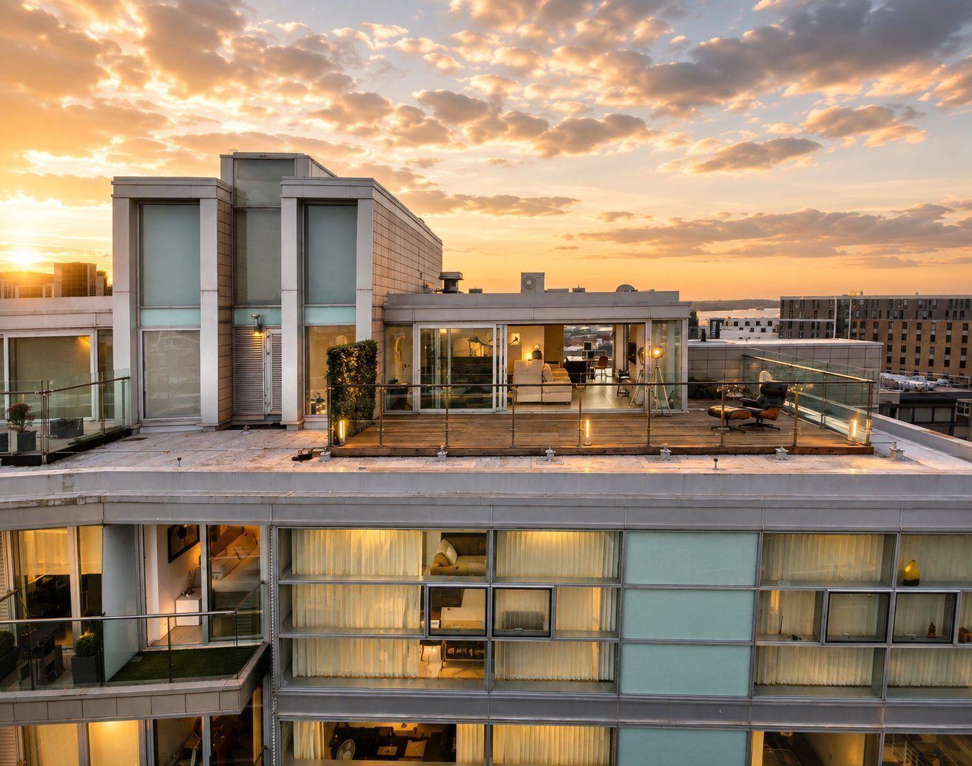 Un bâtiment moderne à plusieurs étages, doté de grandes fenêtres et d’une terrasse sur le toit.