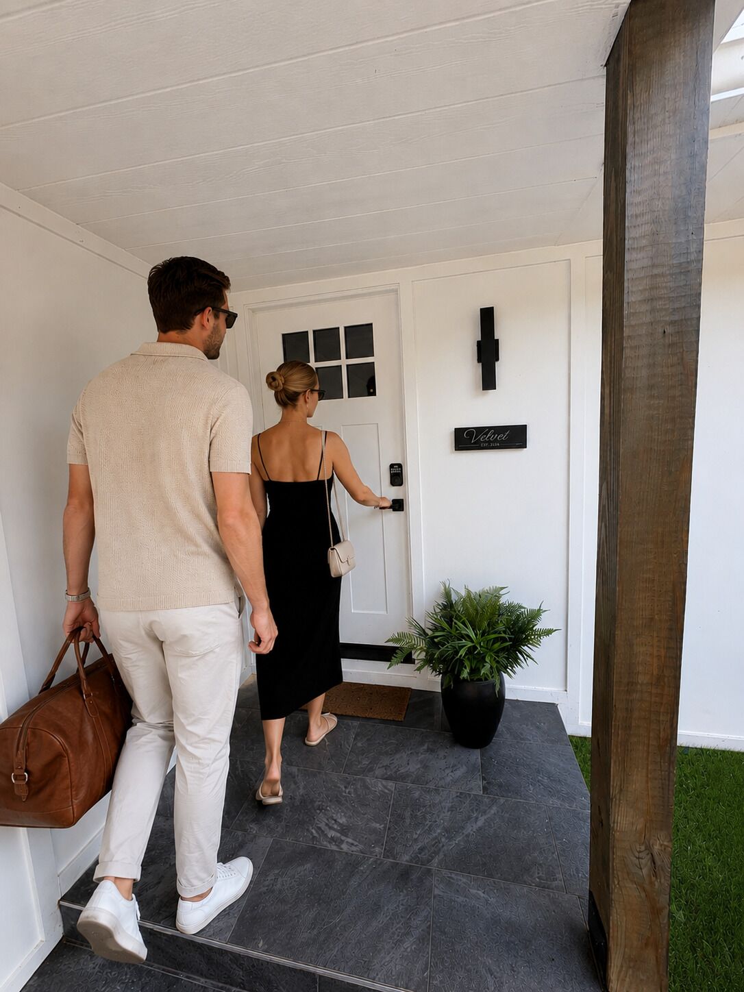 Un hombre y una mujer caminando hacia una puerta con un letrero que dice 'Velvel'.
