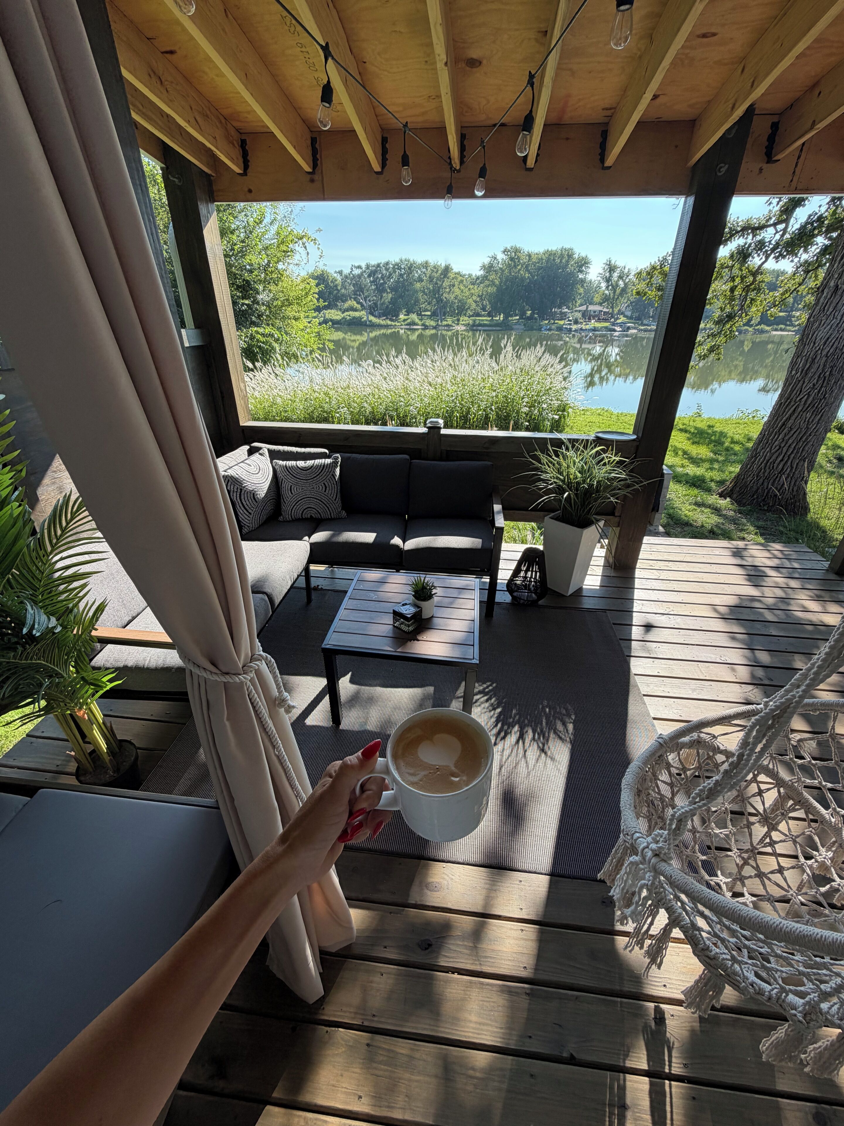 A wooden deck with a sofa, a table, and a chair.