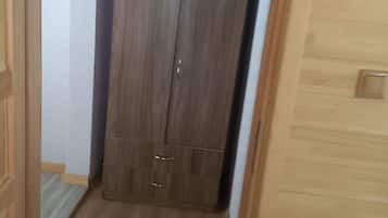 Ein schmaler Flur mit einem Holzschrank und einer Tür links.
