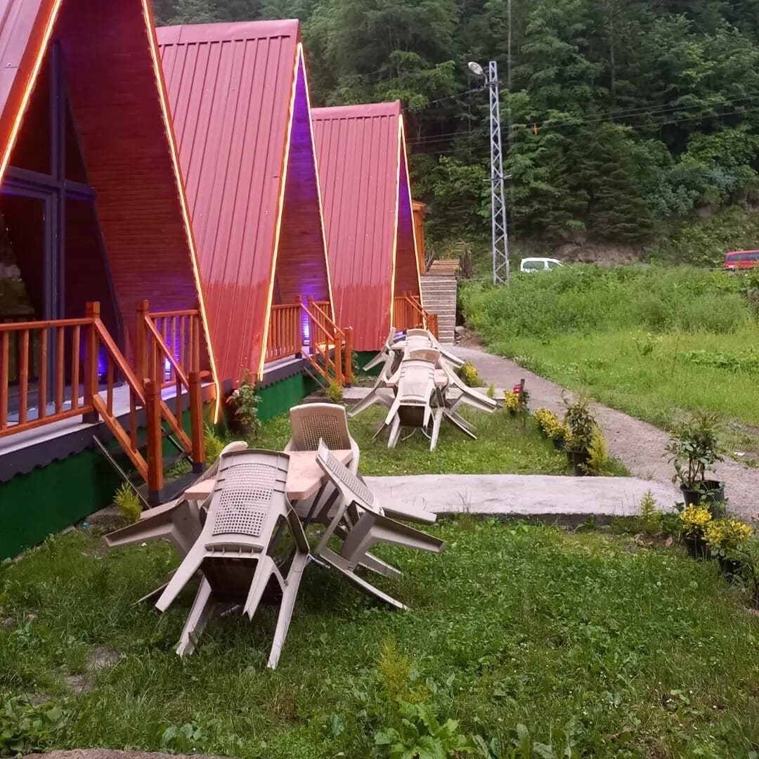 Cabañas con techos triangulares y zonas de estar al aire libre.