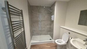 A bathroom with a shower, toilet, and sink. - Central 1BR Apartment in Hull’s Historic Old Town (Kingston upon Hull)