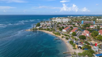 Un pueblo costero con playa, hoteles y un puerto deportivo.