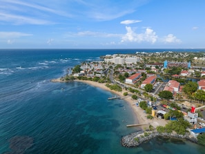 A coastal town with a beach, hotels, and a marina.