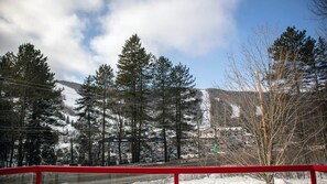 Schneebedeckte Landschaft mit Bäumen und einem Gebäude im Hintergrund.