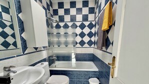 Ein Badezimmer mit Badewanne, Toilette und Waschbecken.