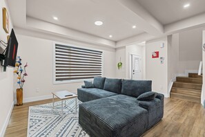 Een moderne woonkamer met een modulaire bank, een klein tafeltje en een kamerkleed met een patroon.