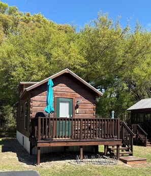 A wooden cabin with a porch, a door, and a mailbox.
