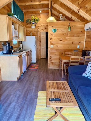 A wooden interior with a kitchen, dining area, and seating space.