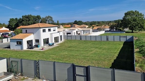 Et boligområde med moderne huse, en græsplæne og en blå himmel.