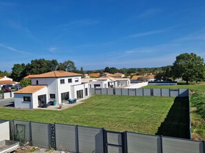 Ein Wohngebiet mit modernen Häusern, einem Rasen und blauem Himmel.