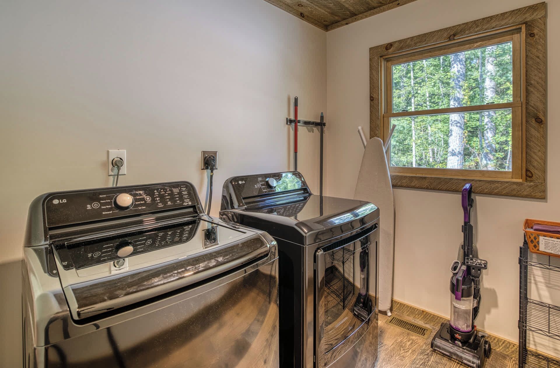 A laundry area with two washing machines and a vacuum cleaner.