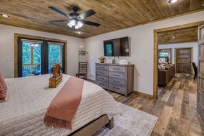 Ein Schlafzimmer mit Bett, Kommode und Deckenventilator.