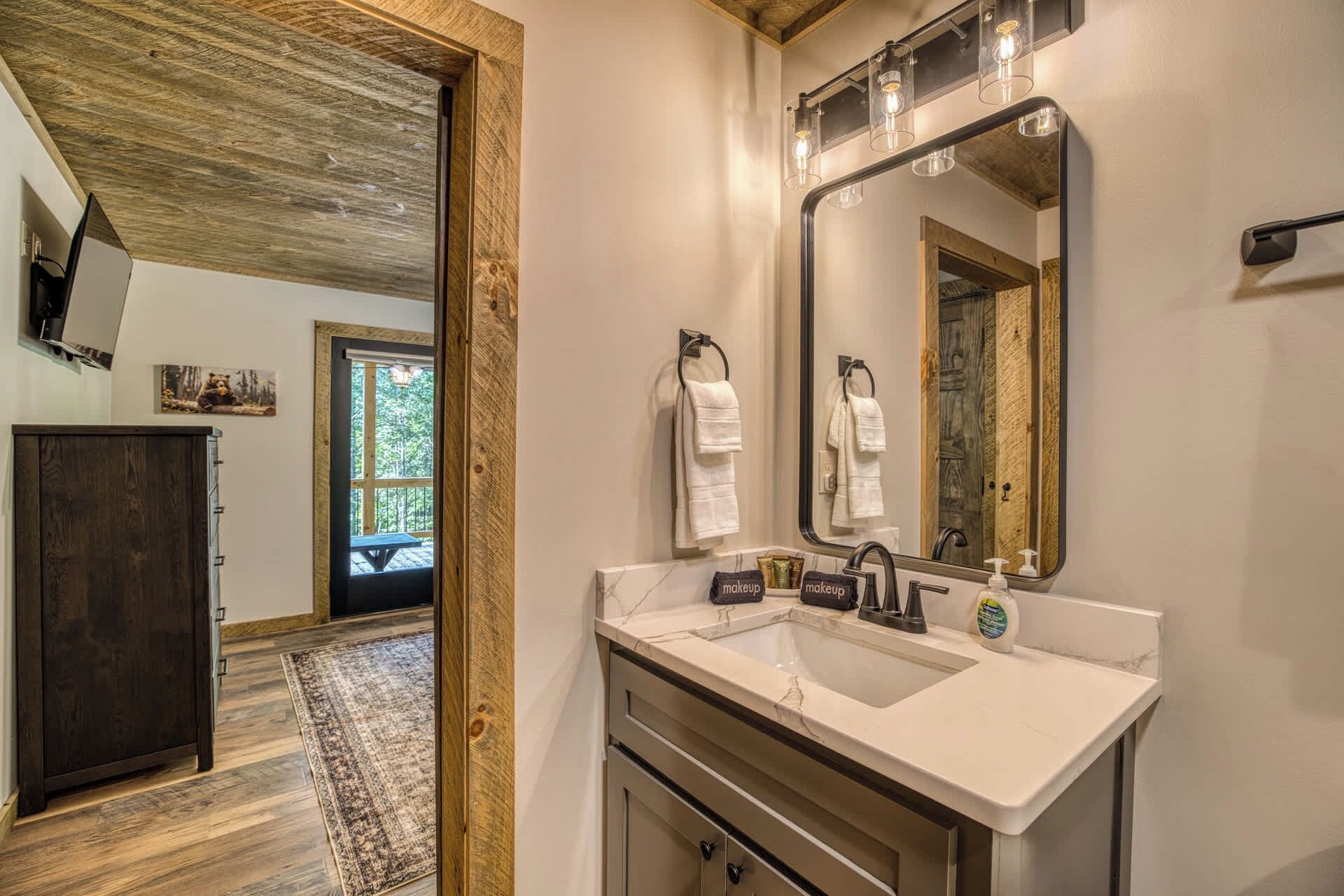Une salle de bain avec un grand miroir, un lavabo et un porte-serviettes.