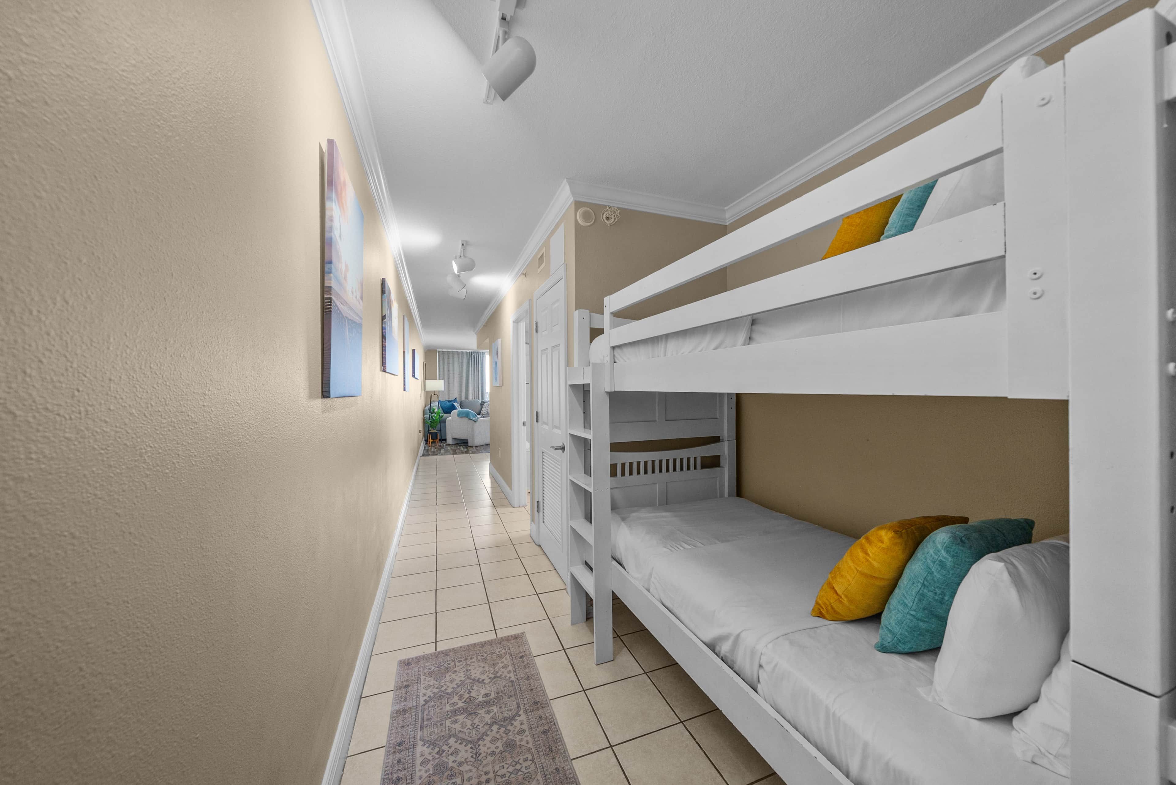 A bunk bed room with a hallway leading to a bathroom.