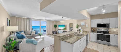 A modern apartment with a living area, kitchen, and a balcony with a view.